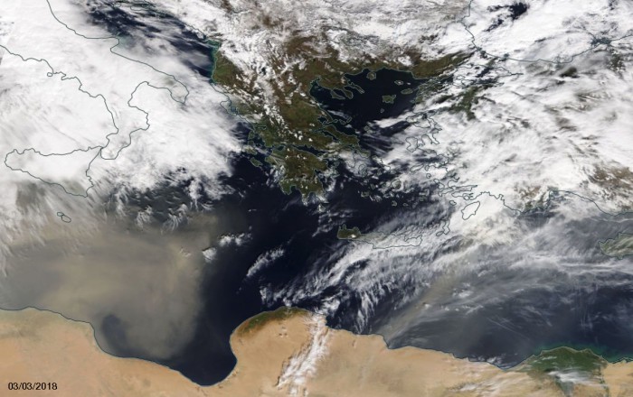 Εικόνα από τον δορυφόρο Terra της NASA το μεσημέρι του Σαββάτου 3 Μαρτίου 2018.  Όπως εξηγεί ο Μανώλης Λέκκας, φαίνεται καθαρά η διαφορά της μεταφοράς σκόνης απο τα ΝΔ της Κρήτης (απόχρωση καφέ και ιδιαίτερα διαφοροποιημένη από τα λευκά νέφη), προερχόμενη από τις ακτές της Αφρικανικής Ηπείρου και με την κίνηση των αέριων ρευμάτων μεταφέρθηκε προς την περιοχή μας. Φαίνεται άλλη μία μεταφορά απο τα ΝΑ της Κρήτης στα σύνορα Λιβυης και Αιγύπτου , αλλά δεν είναι ιδιαιτέρως εμφανής λόγω του οτι είναι ασθενέστερη αλλά και απο το γεγονός ότι υπάρχει και περισσότερη νέφωση.  